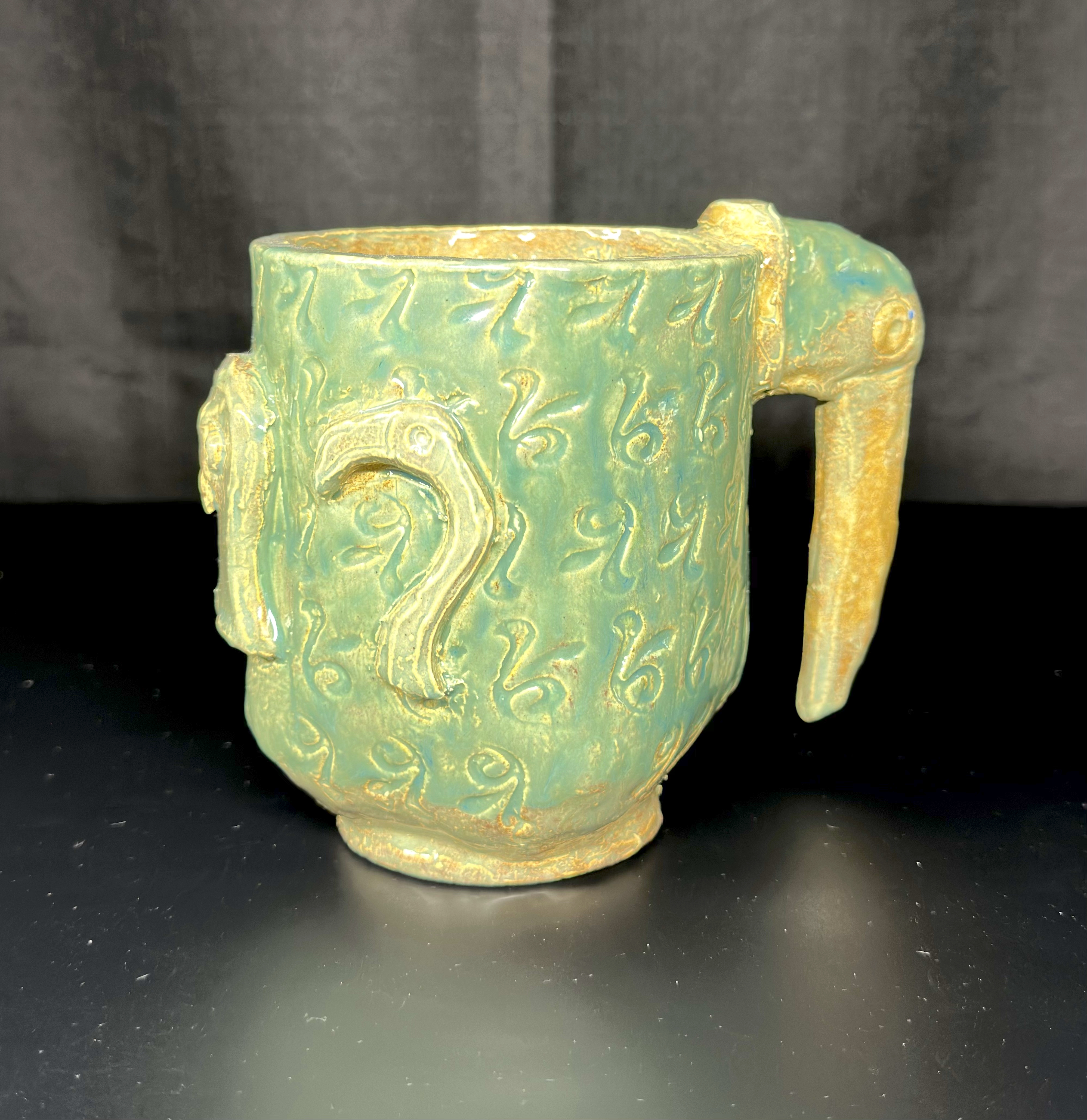 Tropical Bird Mug: a glazed ceramic work combining a functional mug form with an imaginative tropical bird design.